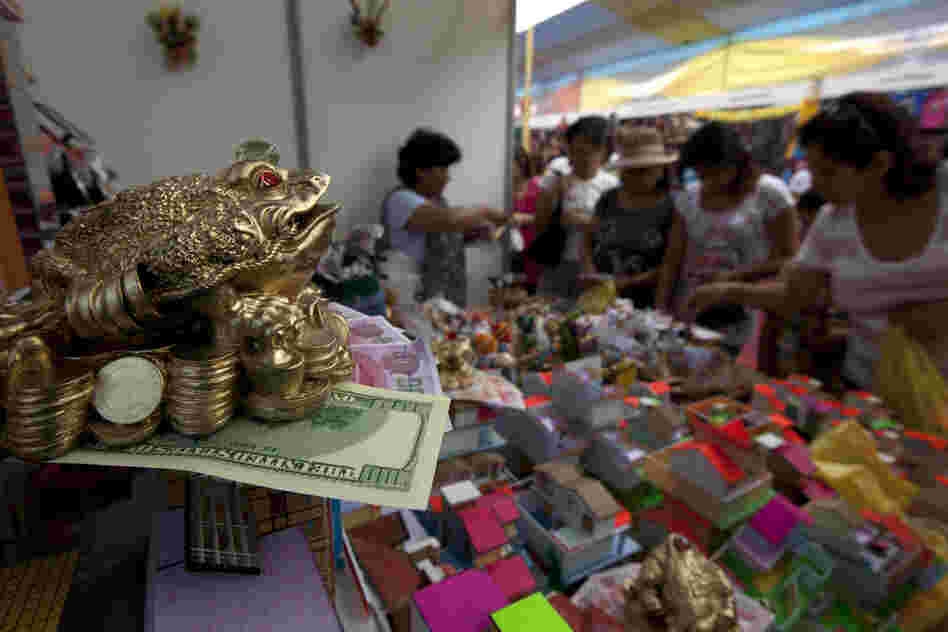 Fake money and coins along with small-scale homes are displayed at the Market of Wishes in Lima, Peru. As part of their New Year's traditions, Peruvians buy miniature representations of the things they desire to acquire in the coming year.