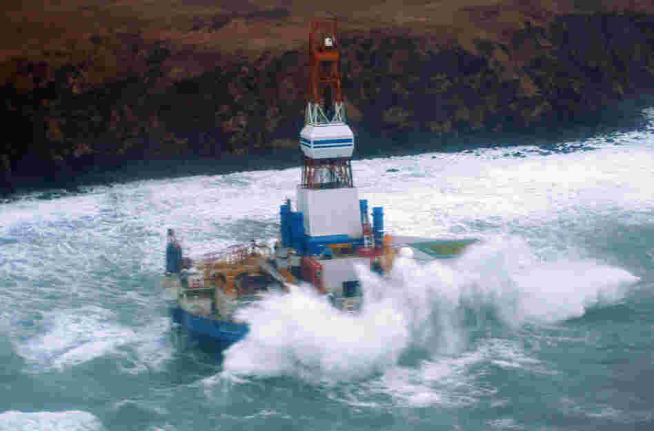 Waves crash over the Kulluk oil rig, which washed aground on Sitkalidak Island, Alaska. Officials say aircraft have not spotted any signs of a fuel leak from the rig, which reportedly does not contain crude oil.
