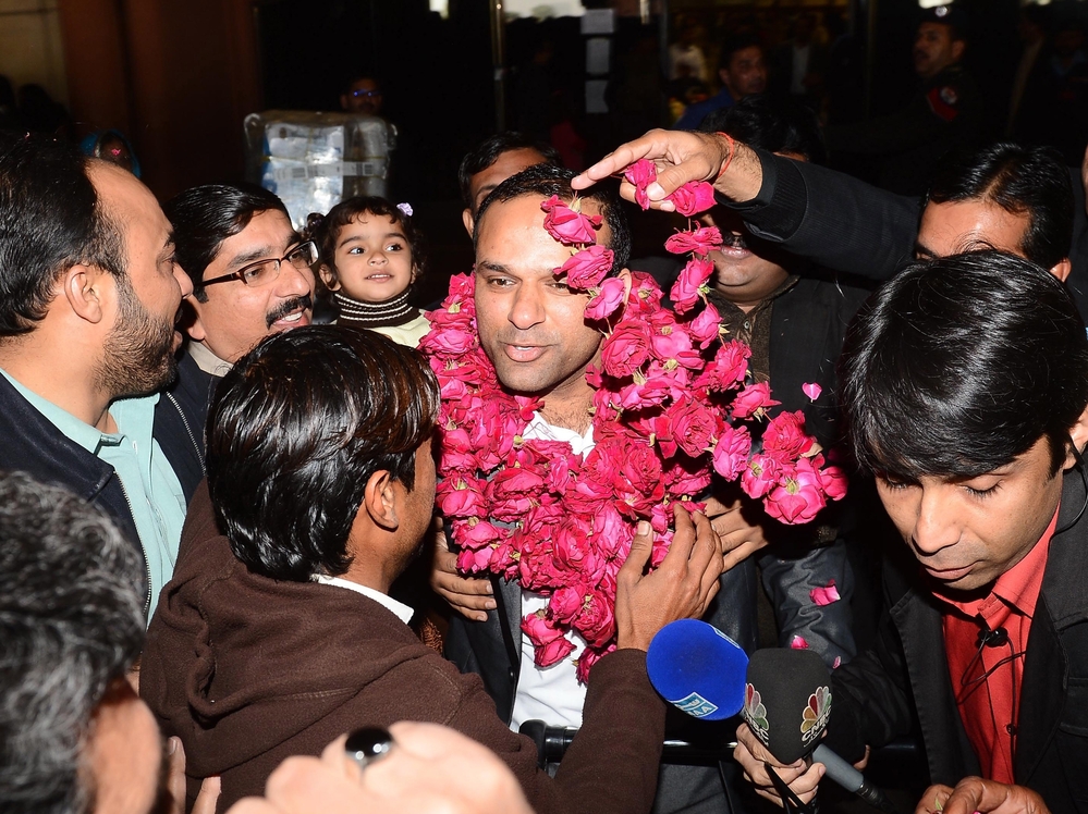Pakistanis welcome Muhammad Shahid Nazir, center, the singer of "One Pound Fish," at Lahore's airport Thursday.