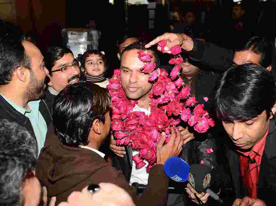 Pakistanis welcome Muhammad Shahid Nazir, center, the singer of "One Pound Fish," at Lahore's airport Thursday.