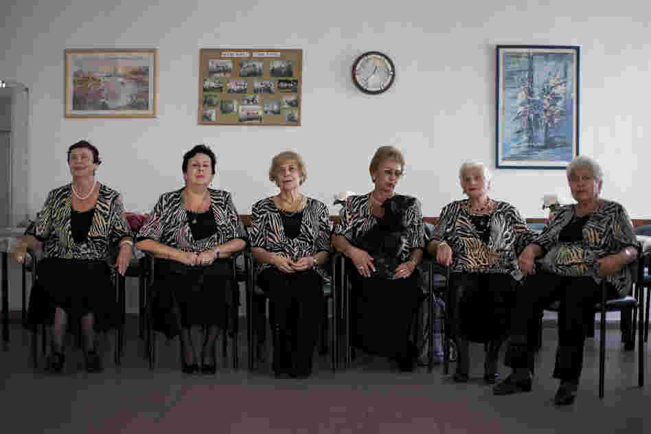 A choir practices in a government-funded elderly care facility catering to Russian-speaking immigrants in Ashdod. The choir sings Russian standards and Israeli folk songs translated into Russian.