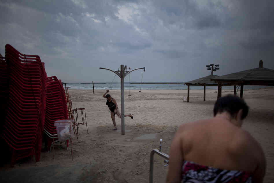 Two immigrants from the Ural region of the former Soviet Union rinse off after bathing in the Mediterranean Sea on an early December morning in Tel Aviv. Many Soviet immigrants gather at the beach for a traditional winter dip, the closest substitute to the freezing waters of the former Soviet Union.