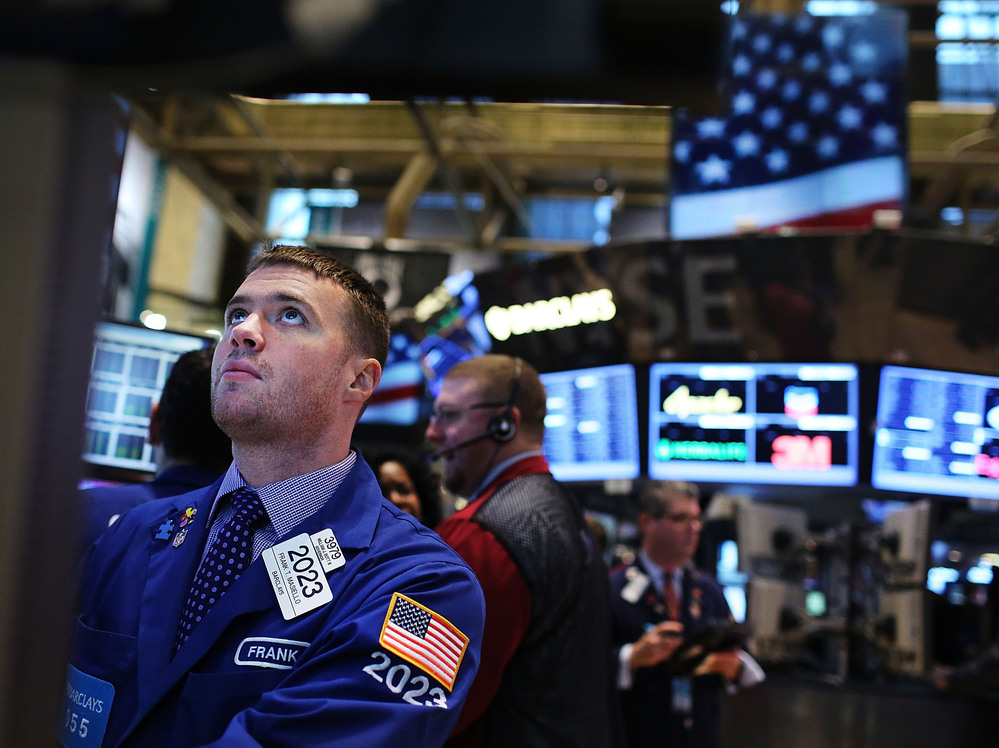 Looking up: Traders on the floor of the New York Stock Exchange earlier today.