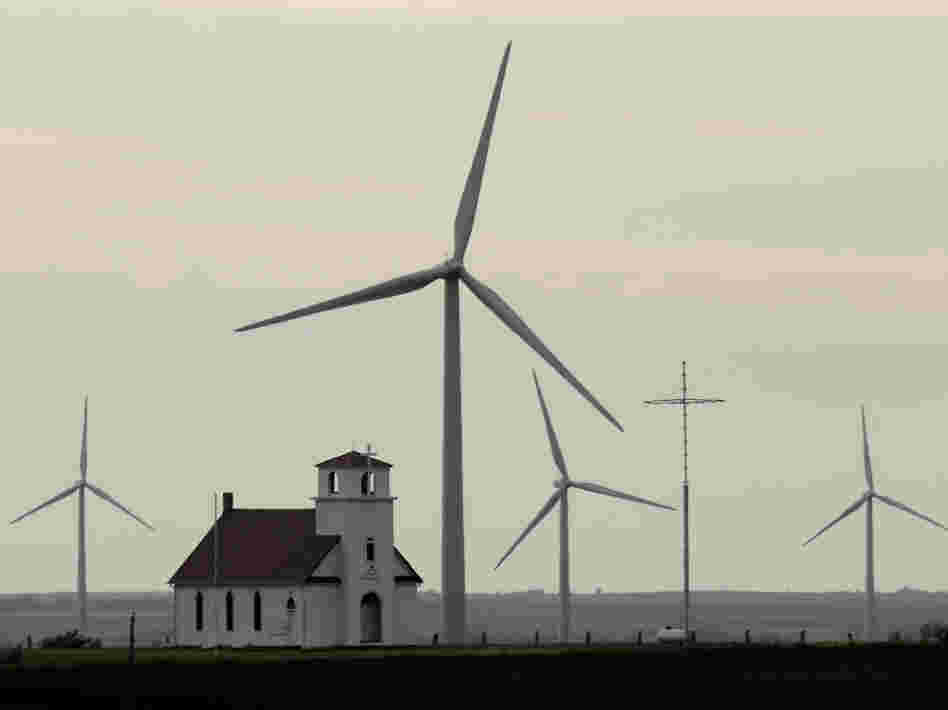 Wind turbines dwarf a church near Wilson, Kan. Although Congress voted to extend a wind energy tax credit, the temporary uncertainty dealt a blow to the industry.