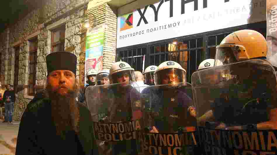 A Greek Orthodox priest is blocked by riot police as he takes part in a protest outside an Athens theater in October. The play, Corpus Christi, portrays Jesus and his apostles as gay men living in modern-day Texas. The director and the cast have been charged under Greece's blasphemy laws.