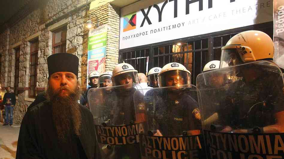 A Greek Orthodox priest is blocked by riot police as he takes part in a protest outside an Athens theater in October. The play, Corpus Christi, portrays Jesus and his apostles as gay men living in modern-day Texas. The director and the cast have been charged under Greece's blasphemy laws.