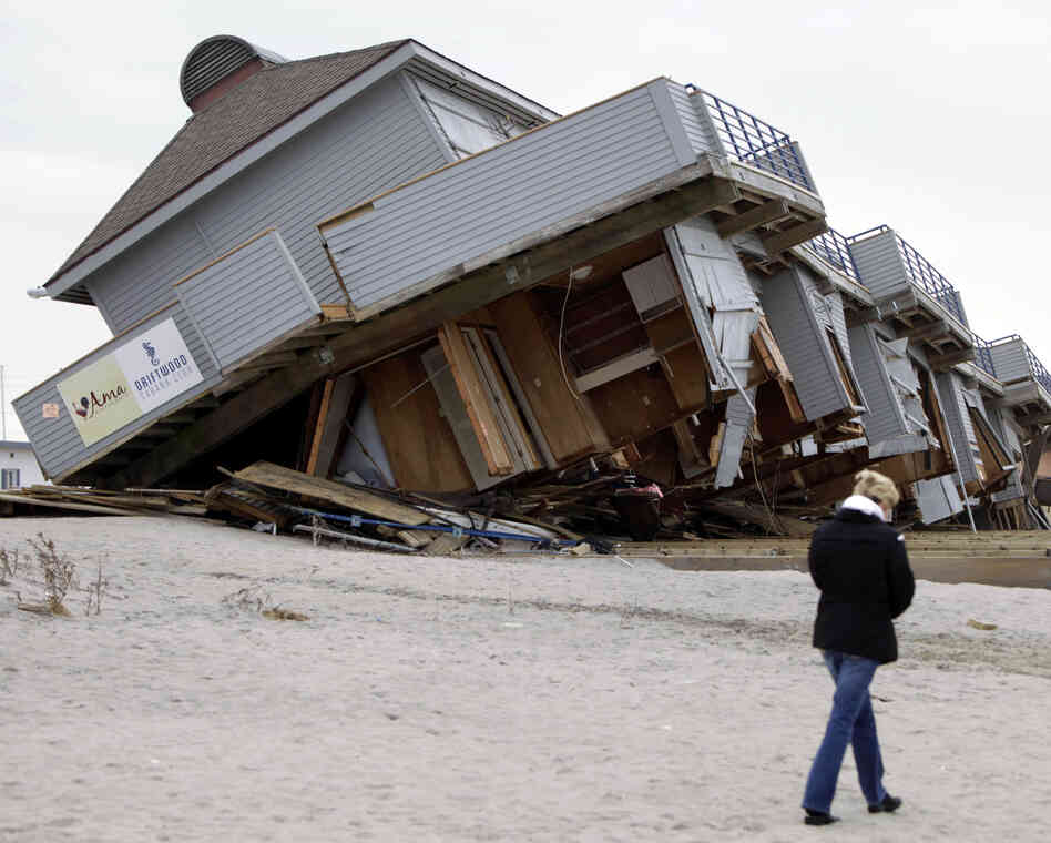 A woman walks past a cabana complex pulled off its foundations by Superstorm Sandy in Sea Bright, N.J., in November.