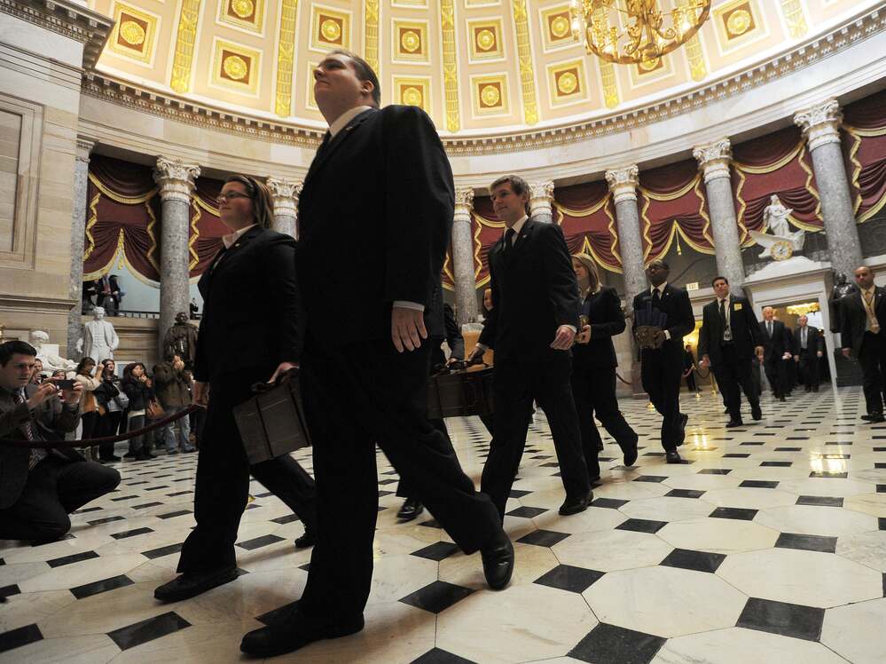 Senate pages carry the "certificate of vote" at the Capitol on Friday.