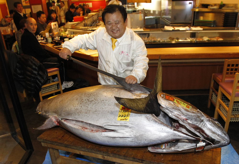 Sushi chain owner Kiyoshi Kimura poses with a bluefin tuna in front of his Sushi Zanmai restaurant in Tokyo on Saturday. He paid more than $1.7 million for the fish.