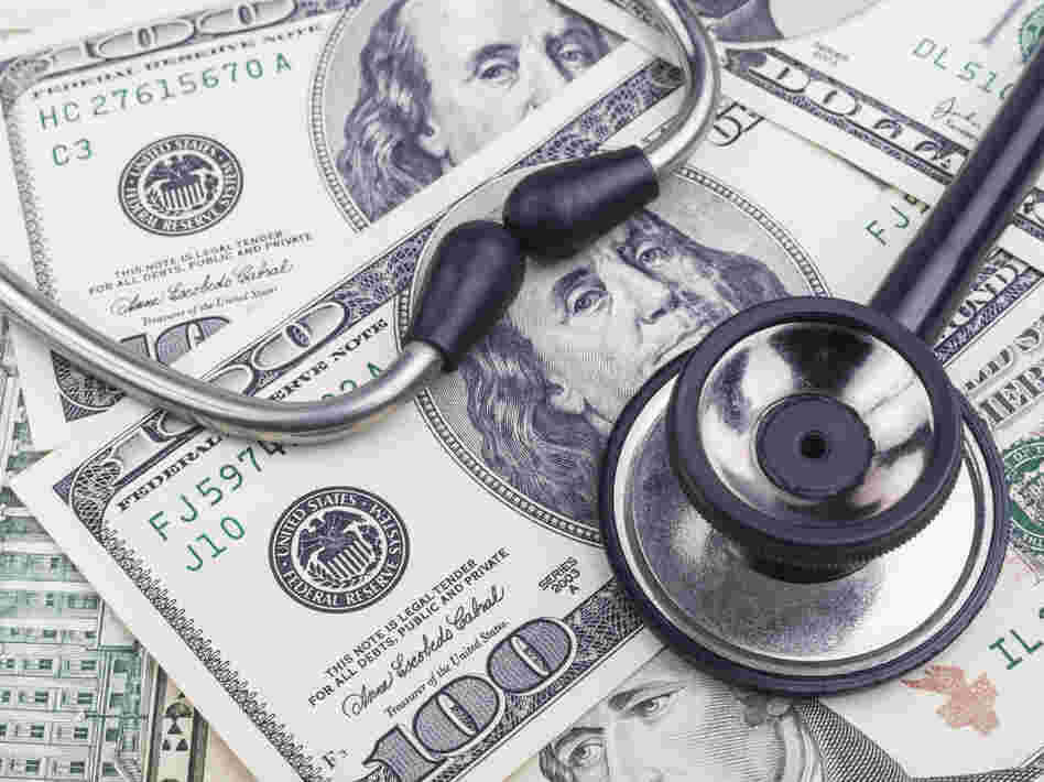 Black stethoscope close-up on top of dollar banknotes