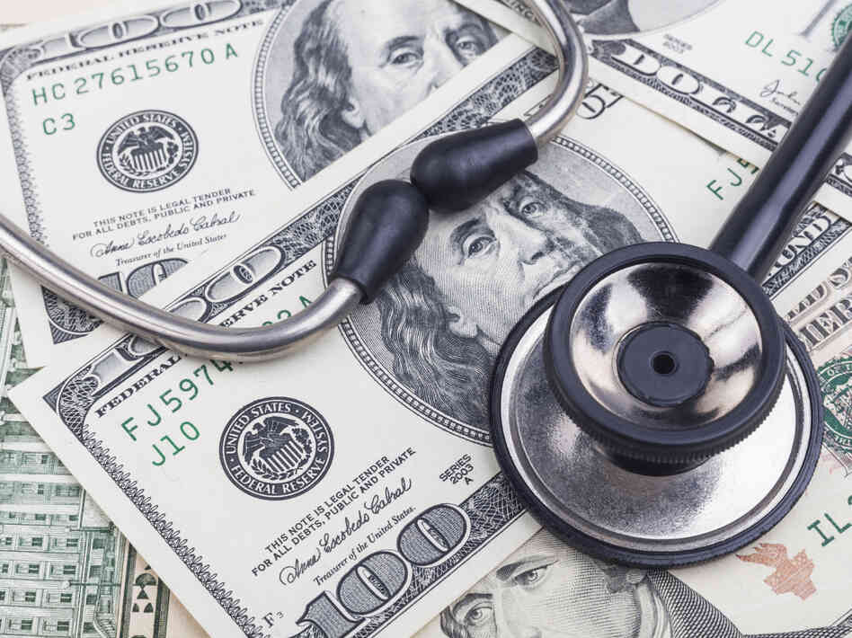 Black stethoscope close-up on top of dollar banknotes