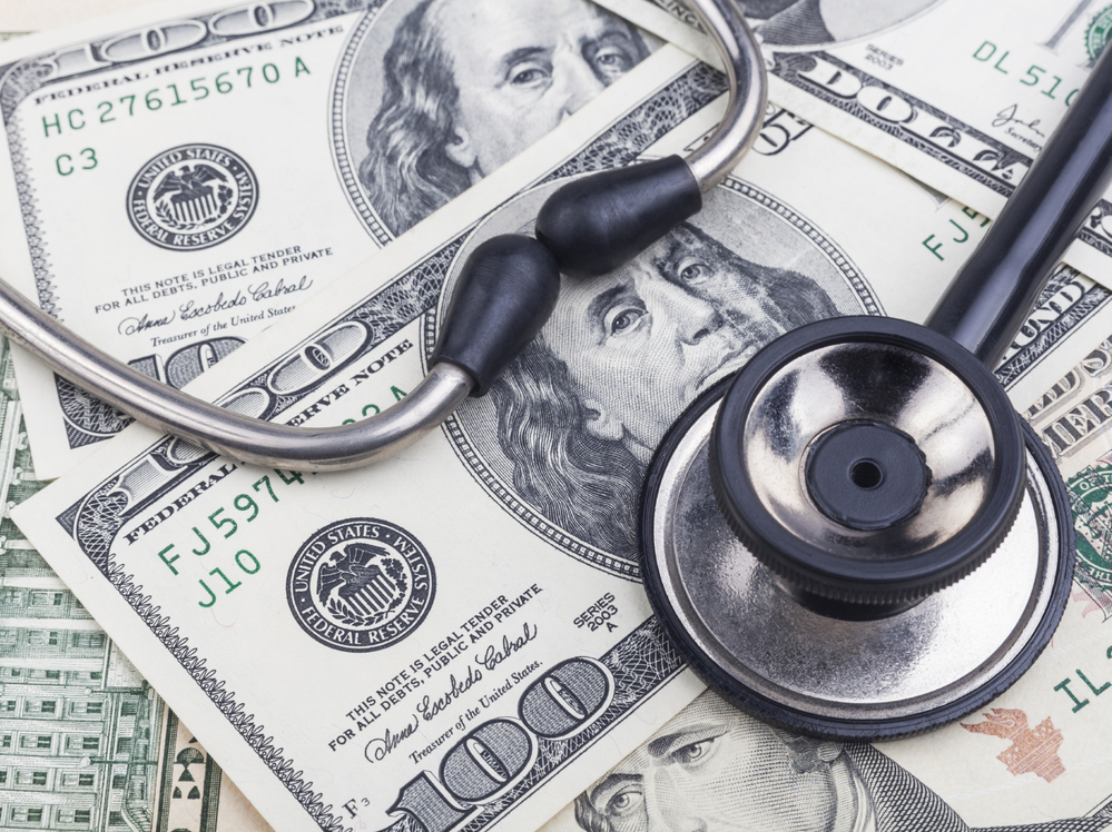 Black stethoscope close-up on top of dollar banknotes Black stethoscope close-up on top of dollar banknotes