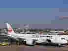 A Japan Airlines Boeing 787 Dreamliner jet aircraft is surrounded by emergency vehicles while parked at a Terminal E gate at Logan International Airport in Boston on Monday. A small electrical fire filled the cabin of the JAL aircraft with smoke about 15 minutes after it landed in Boston.