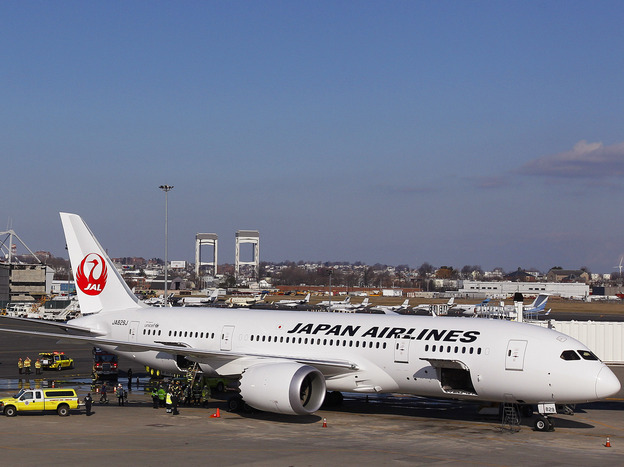 A Japan Airlines Boeing 787 Dreamliner jet aircraft is surrounded by emergency vehicles while parked at a Terminal E gate at Logan International Airport in Boston on Monday. A small electrical fire filled the cabin of the JAL aircraft with smoke about 15 minutes after it landed in Boston.