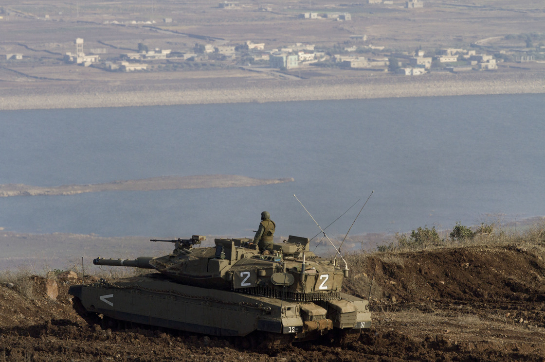 An Israeli tank in the Golan Heights overlooks the Syrian village of Bariqa in November. Israel, which captured the Golan Heights from Syria in 1967, says it's building a fence there because it's concerned about spillover from the Syrian war.