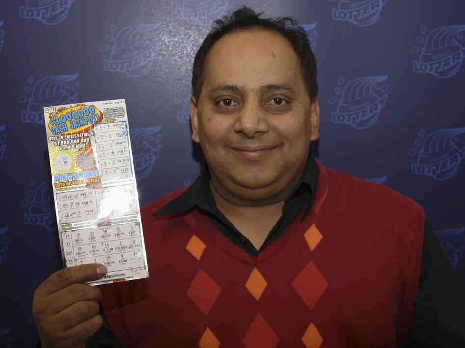 Urooj Khan poses with a winning lottery ticket. He died after winning a $1 million lottery in Chicago. Forensic pathologists at first said Khan died of natural causes, but that ruling was later changed to death by cyanide poisoning.