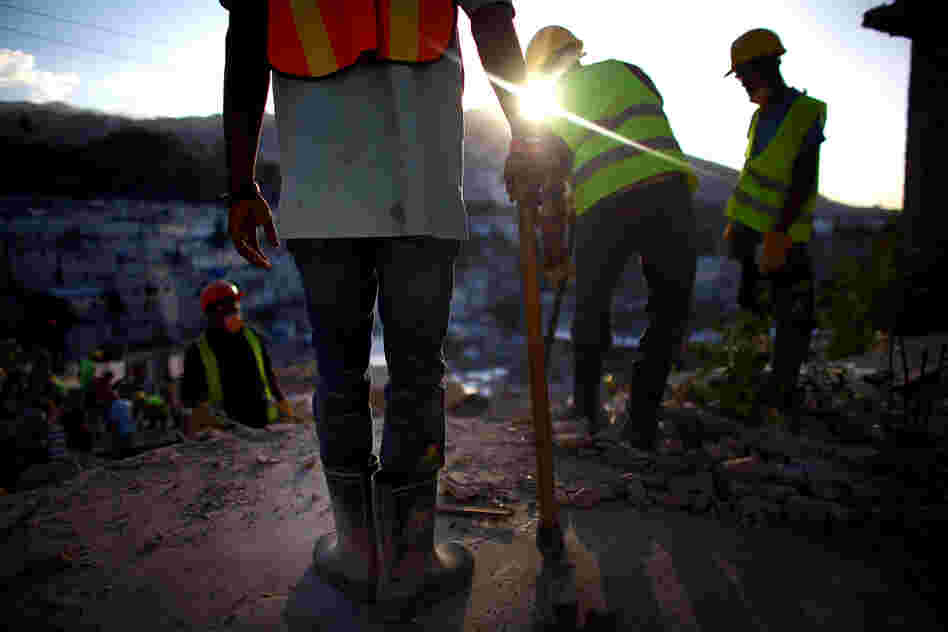 Construction workers overlook the hills above Port-au-Prince near Petionville, where an 18-unit complex is slated to go up this year. Despite billions of dollars in international donations for earthquake relief, only about 5,000 permanent houses have been built.