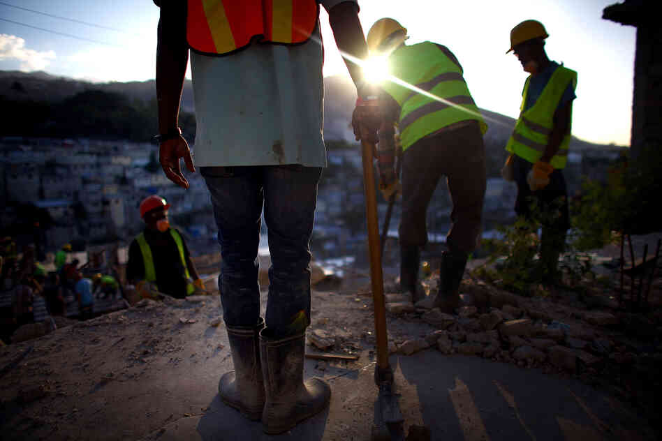 Construction workers overlook the hills above Port-au-Prince near Petionville, where an 18-unit complex is slated to go up this year. Despite billions of dollars in international donations for earthquake relief, only about 5,000 permanent houses have been built.