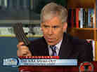 Meet the Press host David Gregory holds what he described as a high-capacity ammunition magazine during the Dec. 23 program.