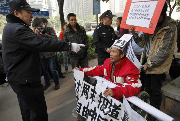 A policeman points to a supporter of Southern Weekly before taking him away during a protest near the newspaper's headquarters Thursday.