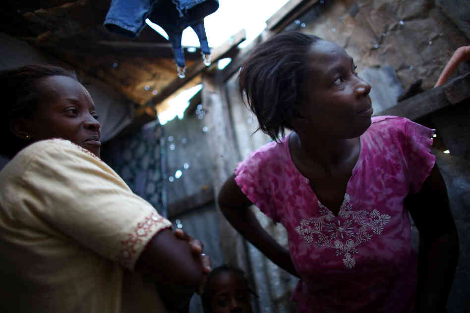 Bibeta Louissaint (left) and Beatrice Rochelain are neighbors in the Fort National neighborhood in Port-au-Prince. Many people who received cash and subsidies to move out of the camps have returned to the area.