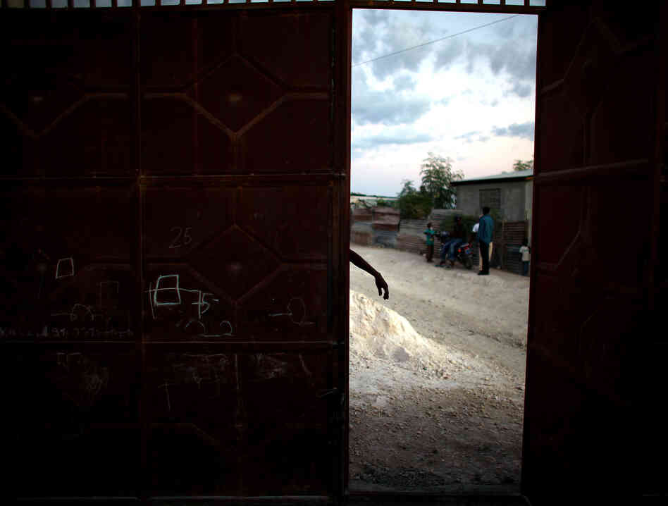 A man works on his steel gate outside of his ramshackle house near Camp Corail, just north of Port-au-Prince.