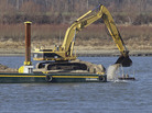 An excavator perched on a barge removes rocks from the Mississippi River in Thebes Ill. An excavator perched on a barge removes rocks from the Mississippi River in Thebes Ill.