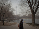 A woman wears a mask while walking in a park near the China Central Television Tower, background, on a hazy day in Beijing. The elderly, children and those suffering from respiratory and cardiovascular diseases are advised to stay indoors to reduce exposure to polluted air. A woman wears a mask while walking in a park near the China Central Television Tower, background, on a hazy day in Beijing. The elderly, children and those suffering from respiratory and cardiovascular diseases are advised to stay indoors to reduce exposure to polluted air.