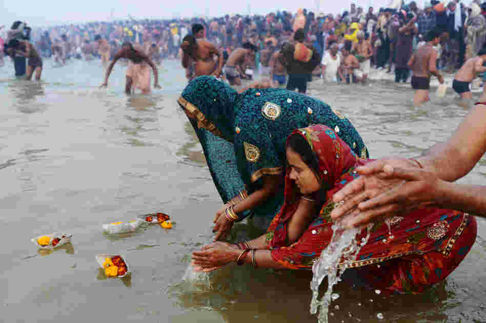 Pilgrims release offerings in the river's current while bathing.