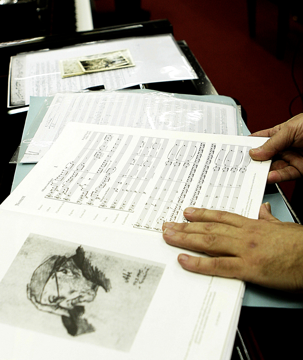 Lotoro displays a copy of music by Rudolf Karel, a Czech composer (in 1945 sketch at left) imprisoned by Nazis for helping the resistance in Prague, in a music shop in Rome, Feb. 22, 2007. Denied access to regular paper, Karel wrote his compositions down on toilet paper. He died of dysentery at the Terezin camp. Lotoro displays a copy of music by Rudolf Karel, a Czech composer (in 1945 sketch at left) imprisoned by Nazis for helping the resistance in Prague, in a music shop in Rome, Feb. 22, 2007. Denied access to regular paper, Karel wrote his compositions down on toilet paper. He died of dysentery at the Terezin camp.