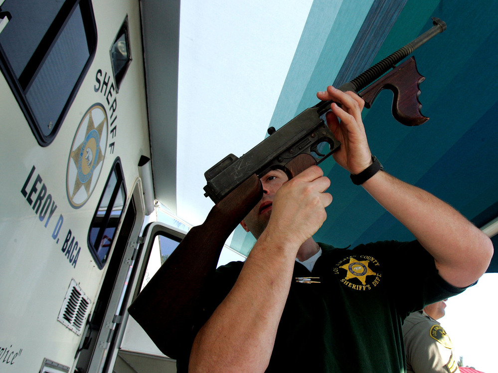 Los Angeles County Sheriff's Department officer Jay Phillippi looks over a fully automatic Thompson machine gun that was turned in during a "Gifts for Guns" program in Compton, Calif., in 2005.