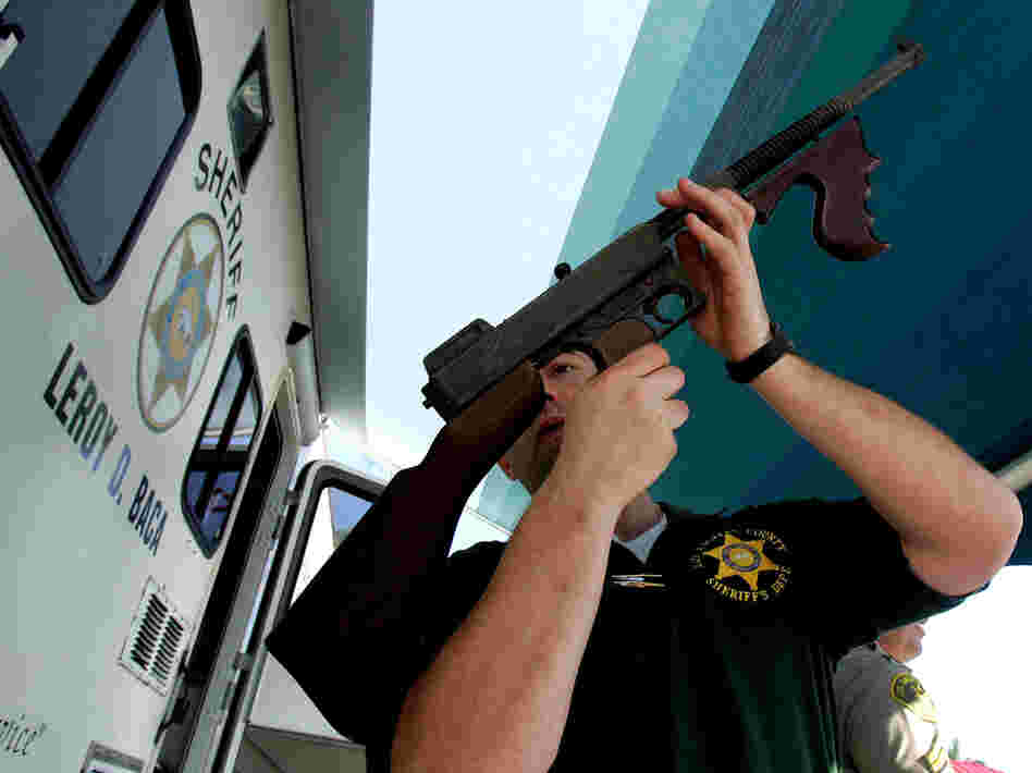 Los Angeles County Sheriff's Department officer Jay Phillippi looks over a fully automatic Thompson machine gun that was turned in during a "Gifts for Guns" program in Compton, Calif., in 2005.