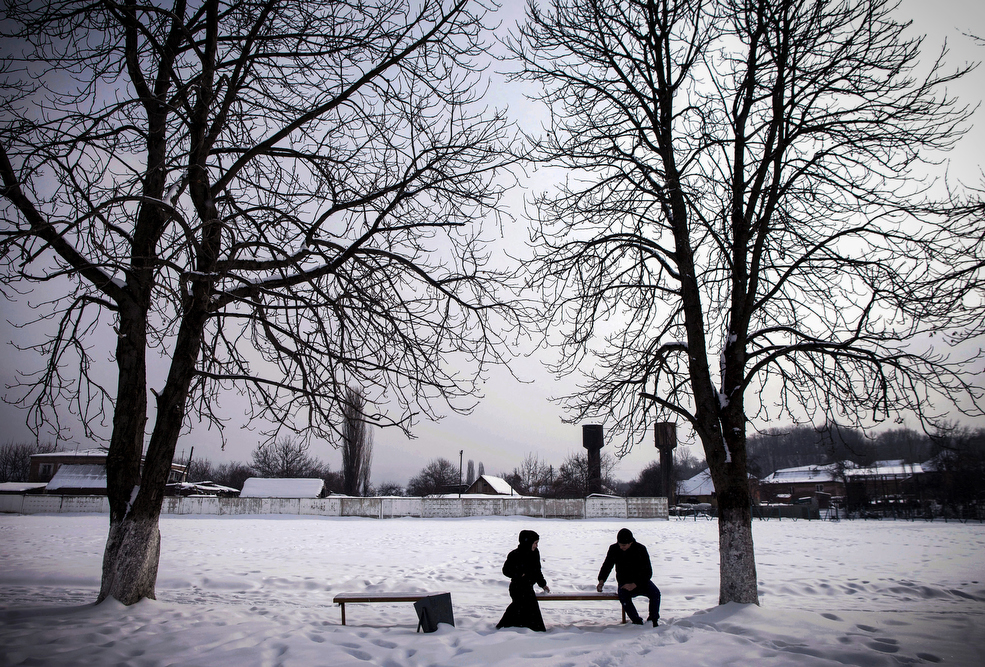 A couple on a date in Serzhen-Yurt. Couples must meet in public and sit at a distance from one another. All physical contact is forbidden before marriage.