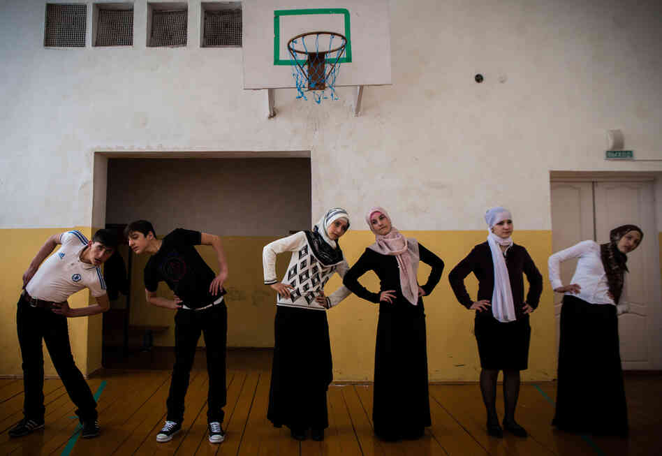 Gym class in Serzhen-Yurt. The schoolgirls, who are dressed in long, flowing skirts and head covers, refuse to wear their gym pants because they say it violates Muslim dress code.