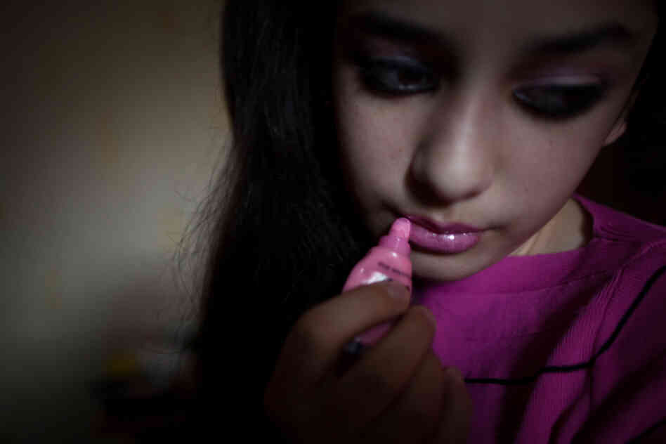 A Chechen teen, who considers herself "emo," puts on lip gloss in her room. Chechen youth who are influenced by the Western "emo" subculture are targets of violence by authorities.