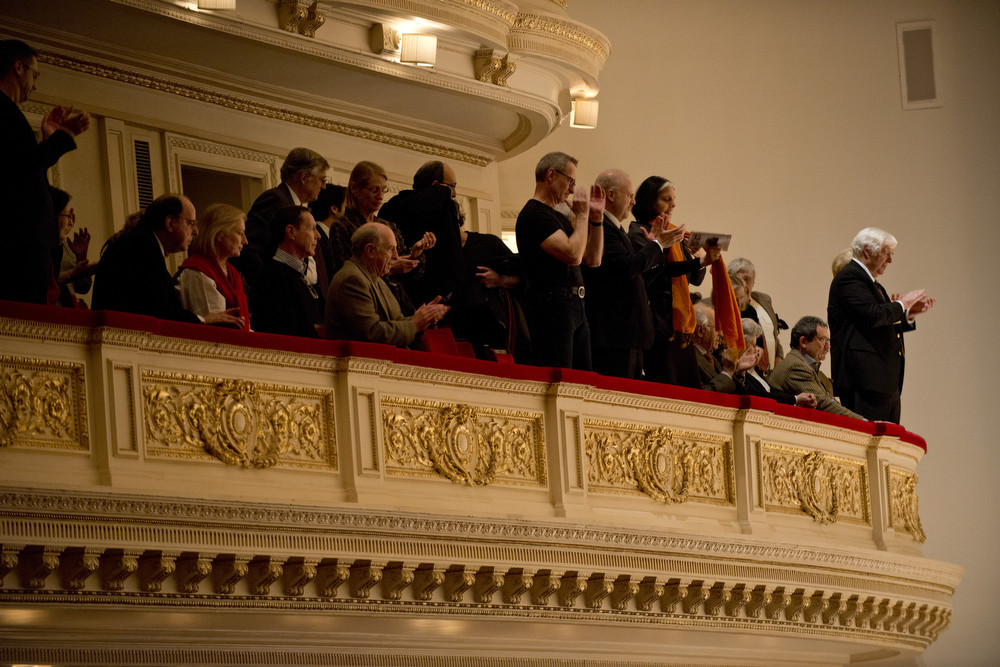 In the balcony at Carnegie Hall, audience members give violinist Leonidas Kavakos and the Philadelphia Orchestra a standing ovation for their performance of the Violin Concerto No. 2 by Karol Szymanowski.