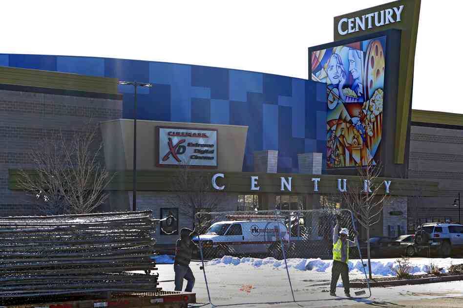 Workers dismantle the fence around the remodeled Century theater in Aurora, Colo., in preparation for the cinema's reopening Thursday. The theater's owner sent 2,000 invitations to the private event, being held for victims' families and first responders.