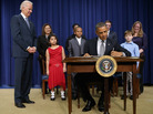President Obama signs a series of executive orders Wednesday about the administration's gun law proposals as Vice President Biden and children who wrote letters to the White House about gun violence look on. President Obama signs a series of executive orders Wednesday about the administration's gun law proposals as Vice President Biden and children who wrote letters to the White House about gun violence look on.