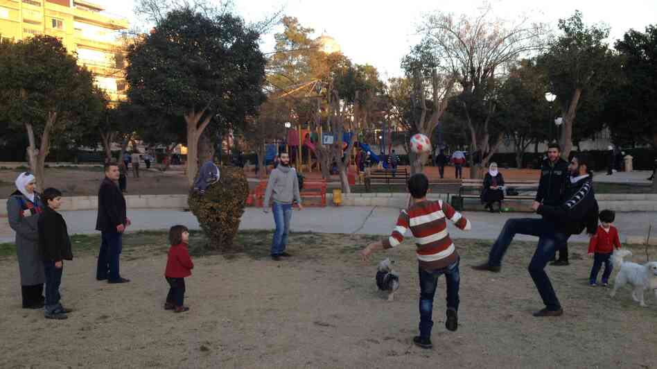 In the Syrian capital, Damascus, many residents try to maintain a normal routine despite the country's war. Here, Damascenes kick a soccer ball in a park.