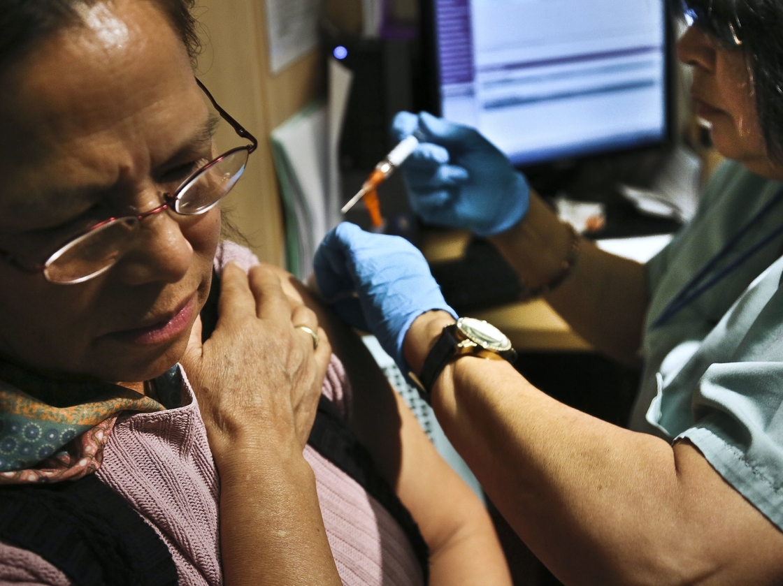 Sonia Despiar, right, a nurse with Gouverneur Healthcare Services, injects Imelda Silva with flu vaccine on Friday, Jan. 11, 2013, in New York. At least 10 elderly people and two children in New York have died from the flu and hospitalizations are climbing as the illness hits every county in the state.
