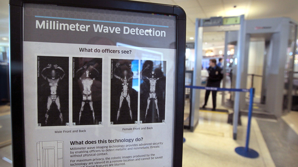 A sign informs travelers about Millimeter Wave Detection technology used in full body scanners at Midway Airport in Chicago. The scanners produce less-revealing images than those that use X-rays. A sign informs travelers about Millimeter Wave Detection technology used in full body scanners at Midway Airport in Chicago. The scanners produce less-revealing images than those that use X-rays.