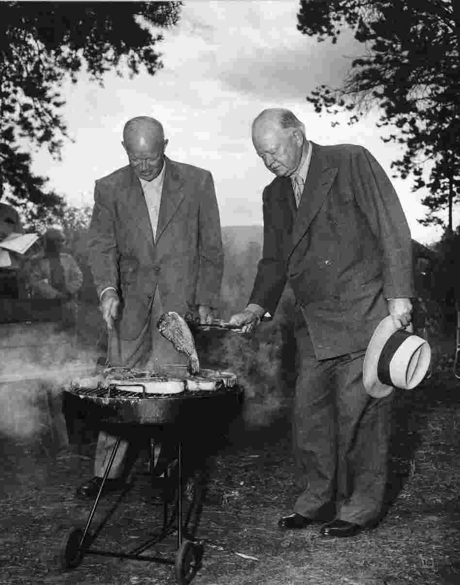 President Eisenhower and former President Herbert Hoover cook steaks on a grill in Fraser, Colo., 1954.
