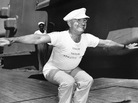 President Truman, wearing a shirt that reads "Coach Truman, Athletic Department," leads exercises on the deck of the USS Missouri on his return trip to Washington from Brazil, 1947. President Truman, wearing a shirt that reads "Coach Truman, Athletic Department," leads exercises on the deck of the USS Missouri on his return trip to Washington from Brazil, 1947.