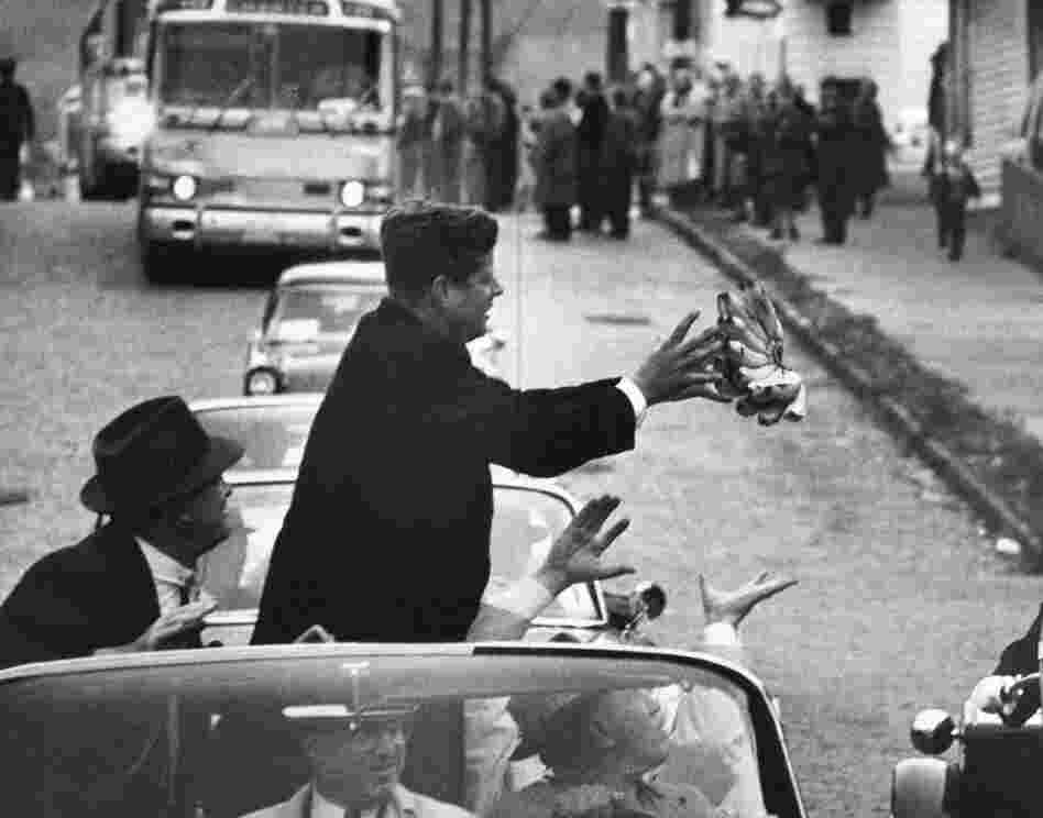 During the 1960 campaign, John F. Kennedy catches a bunch of bananas thrown to him by an admirer.