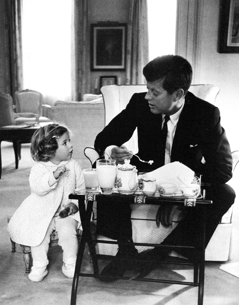 President Kennedy has a breakfast conference with his daughter, Caroline, in the residence area of the White House in 1961.