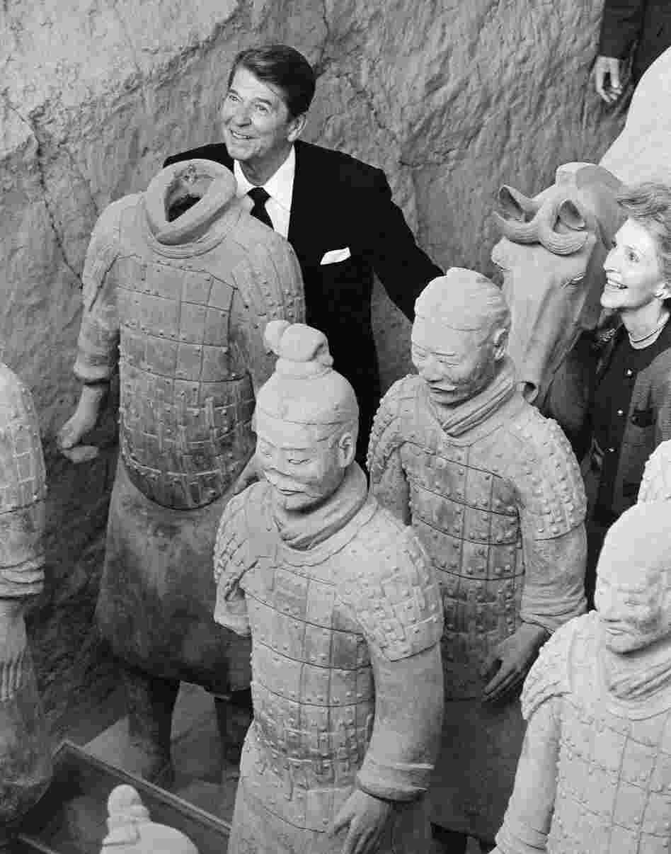 President Reagan stands behind a headless Terra Cotta Warrior as first lady Nancy Reagan looks on during a visit to the ancient historic underground army archaeological find near Xian, China, 1984.