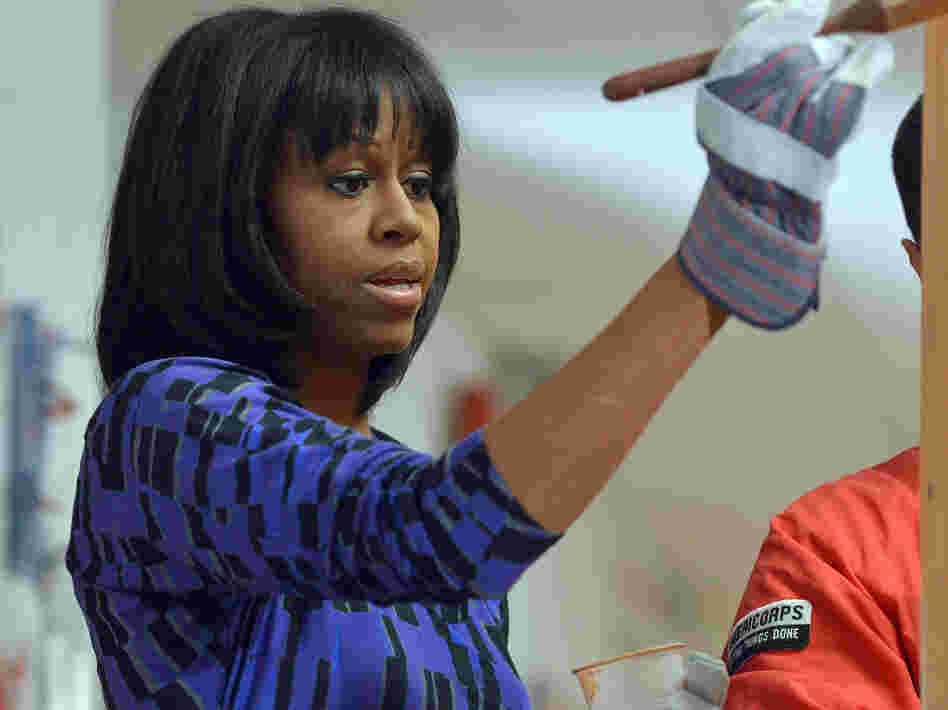First lady Michelle Obama paints a bookshelf at Burrville Elementary School in Washington, D.C., as part of the National Day of Service on Saturday.