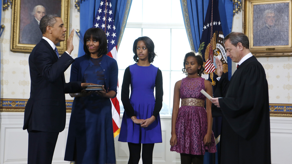 President Obama is officially sworn in Sunday by Chief Justice John Roberts in the Blue Room of the White House. Next to Obama are first lady Michelle Obama, holding the Robinson Family Bible, and their daughters, Malia and Sasha. President Obama is officially sworn in Sunday by Chief Justice John Roberts in the Blue Room of the White House. Next to Obama are first lady Michelle Obama, holding the Robinson Family Bible, and their daughters, Malia and Sasha.