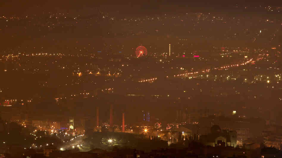A haze of smoke hangs over Athens early Jan. 3. The hazy conditions result from residents' switch to wooden stoves and fireplaces for heating, as many households can no longer afford to buy heating oil.