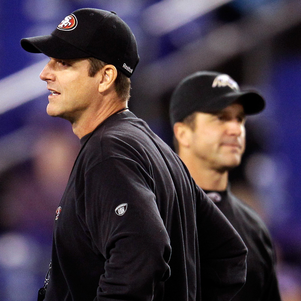 Head coach Jim Harbaugh (left) of the San Francisco 49ers and his brother, head coach John Harbaugh of the Baltimore Ravens, before a game on Thanksgiving Day 2011. Their teams will meet again in the Super Bowl.